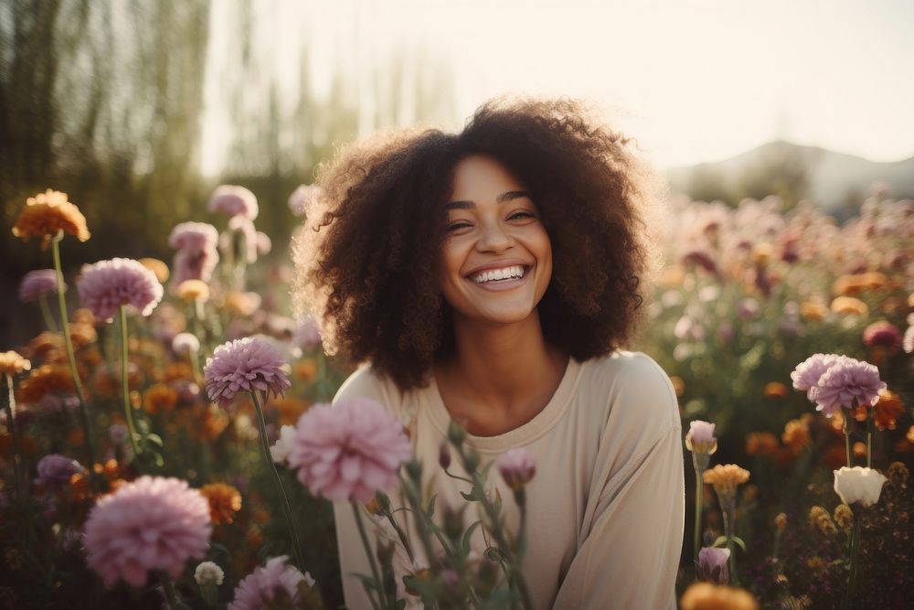 Black woman outdoors flower laughing.