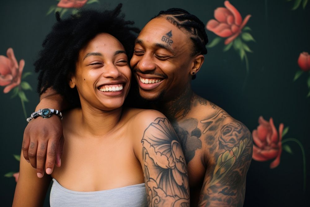 Black couple portrait tattoo laughing.