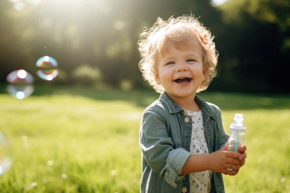 Boy blowing soap bubbles portrait laughing outdoors. AI generated Image by rawpixel.