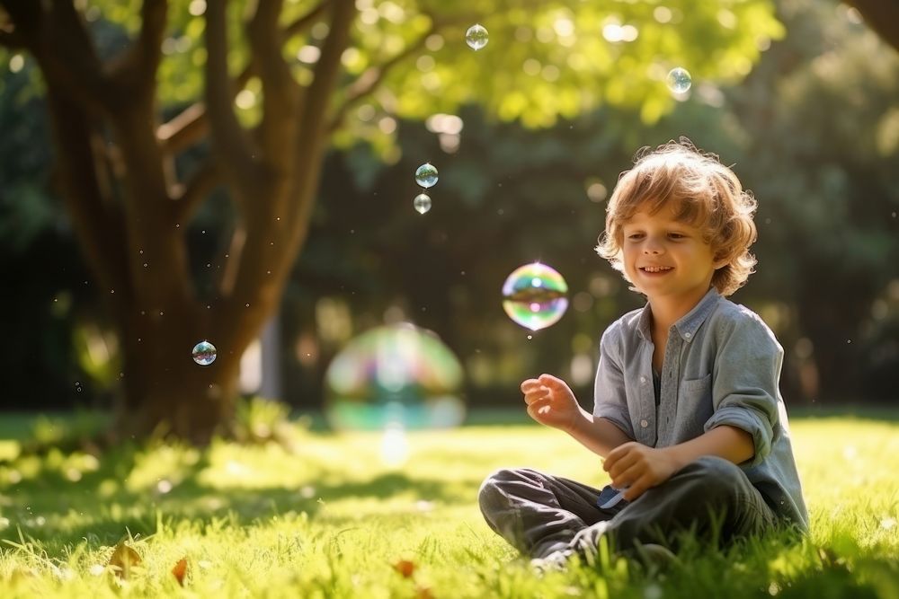 Boy blowing soap bubbles portrait outdoors plant. AI generated Image by rawpixel.