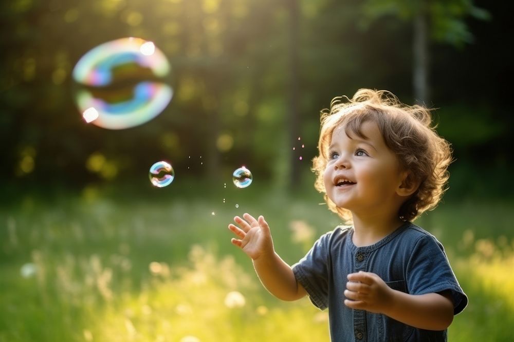 Little boy blowing soap bubbles portrait child cute. AI generated Image by rawpixel.