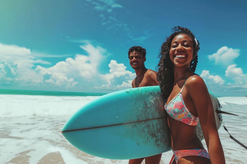 Black woman carrying surfboard with her friend vacation sunny beach.