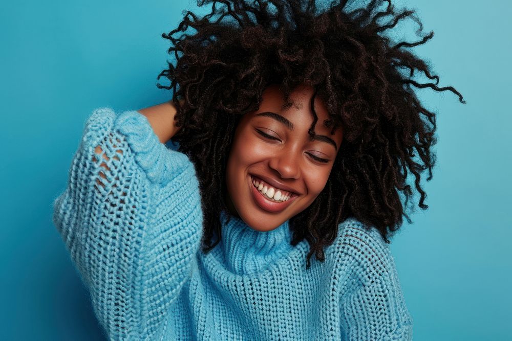 South african woman with a wig and curly hair sweater laughing smile.