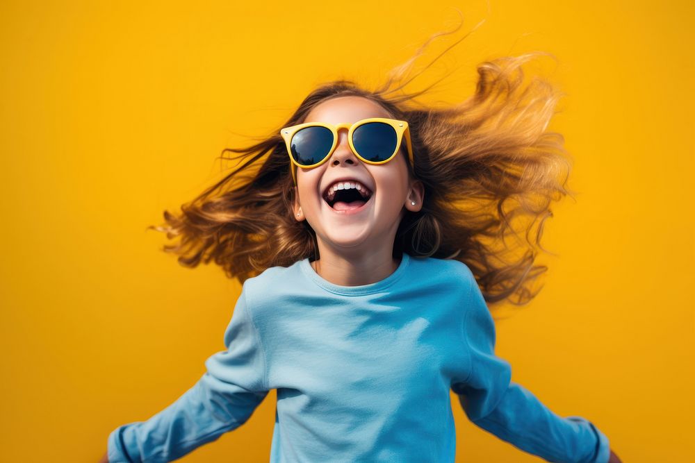 Young girl with sunglasses shouting yellow happy.