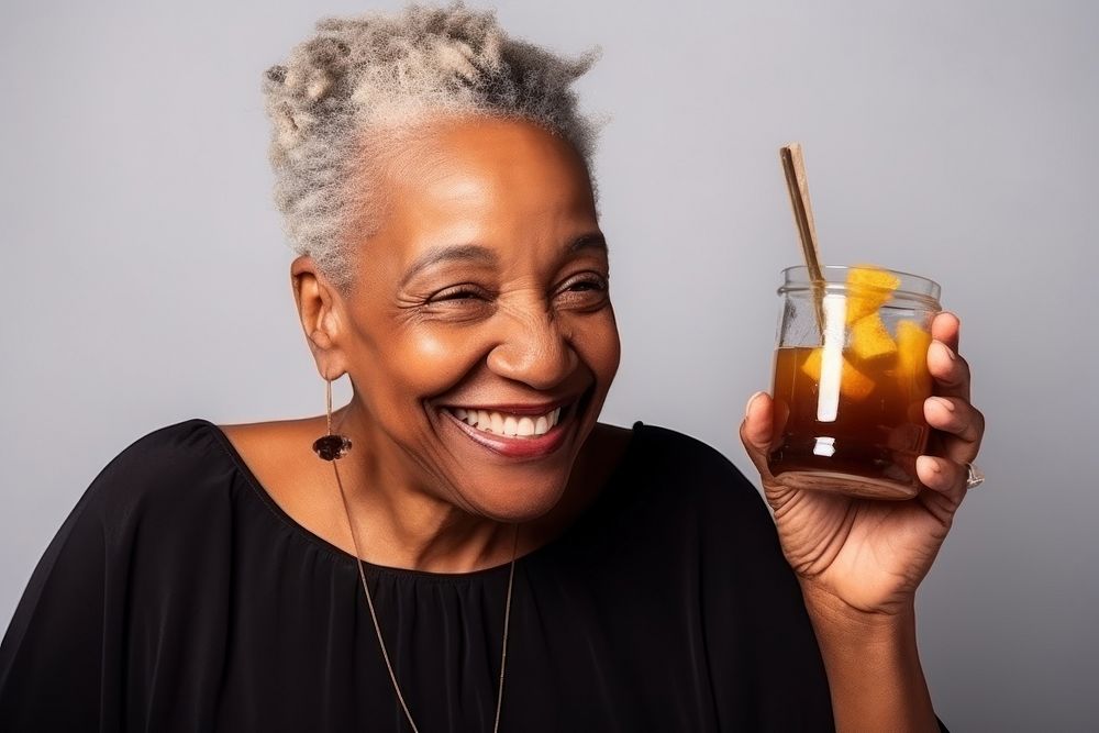African American old woman drinking laughing smiling.