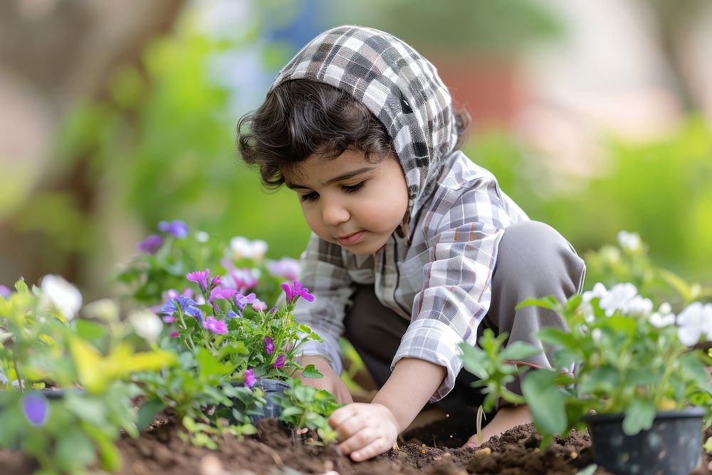 Saudi Arabian kid gardening planting outdoors.