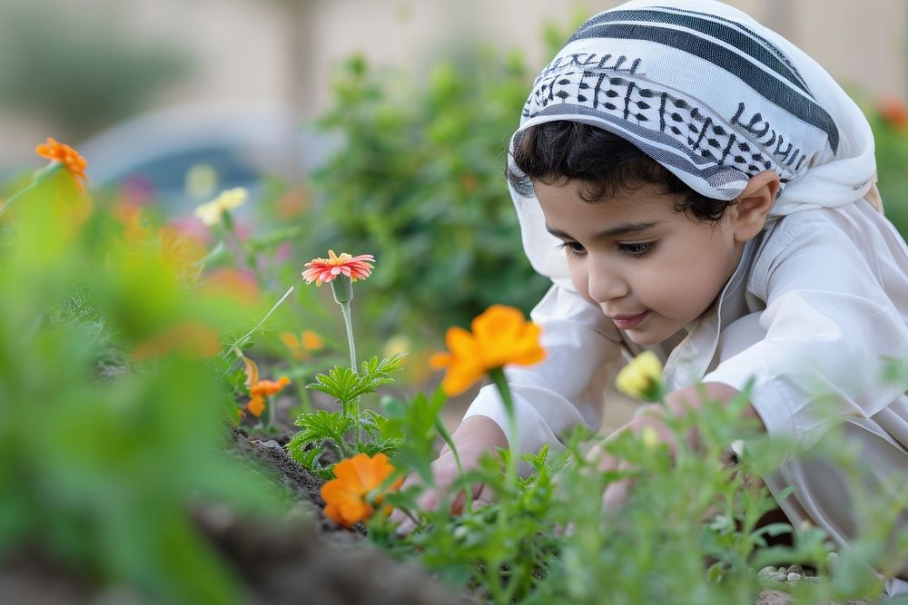 Saudi Arabian kid gardening outdoors flower.