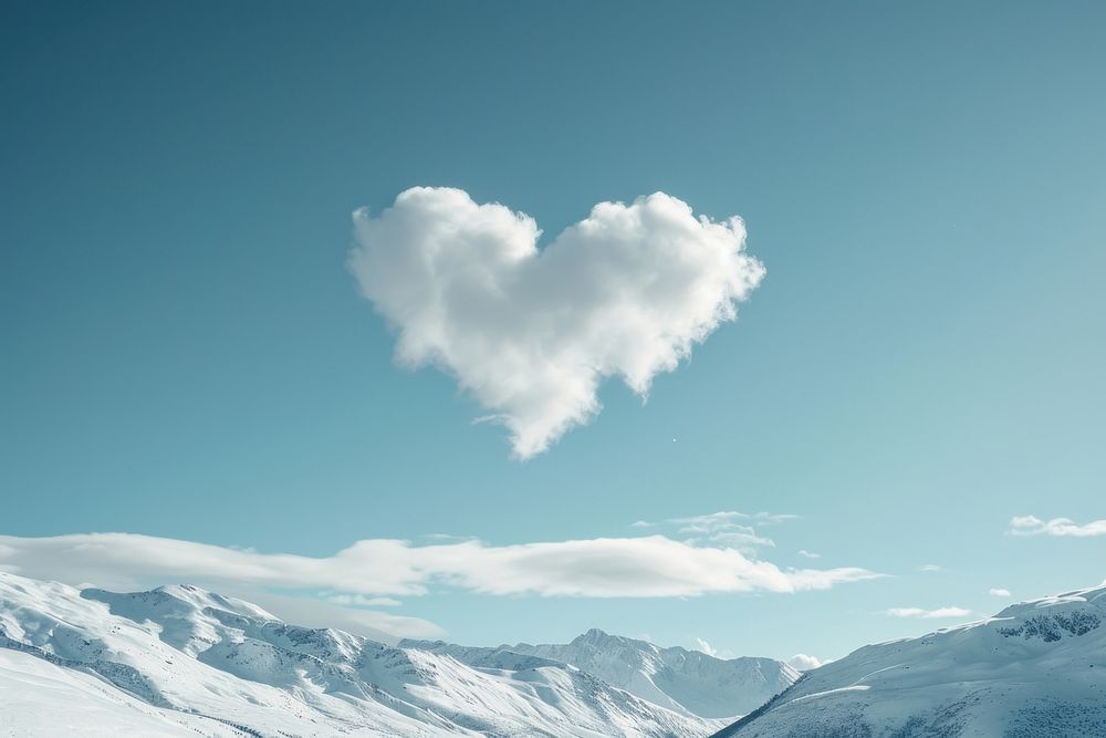 Heart shaped as a clouds in the sky with mountain background outdoors nature snow.