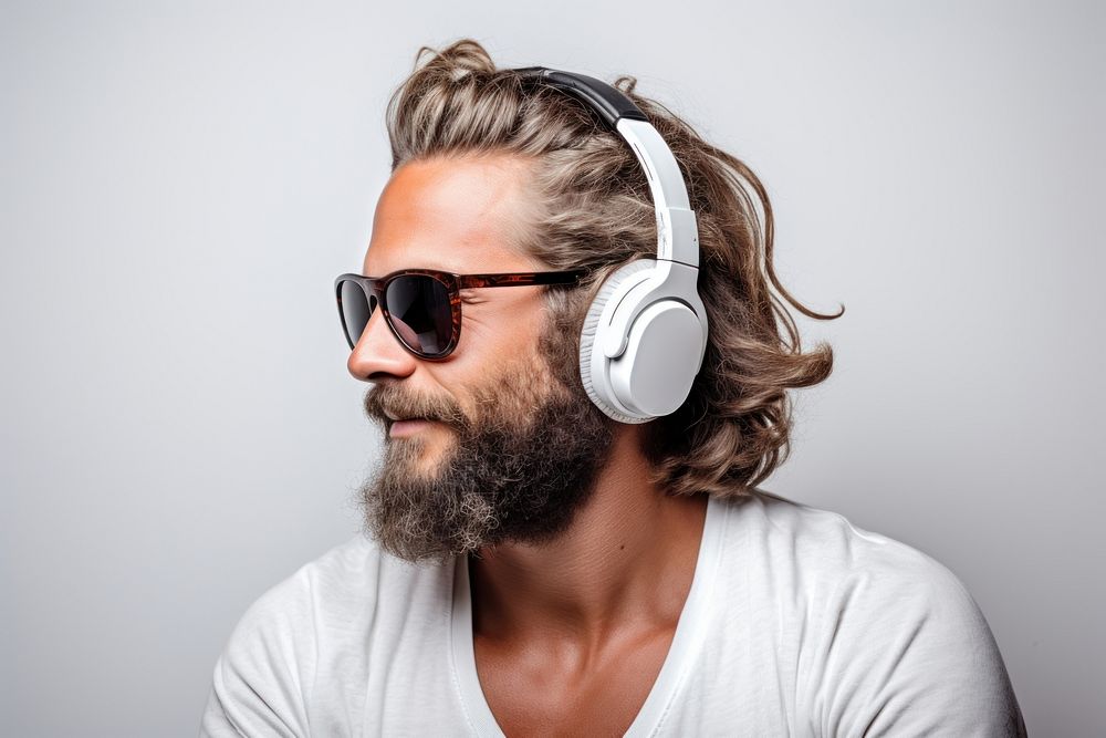 A man with bun hair glasses beard headphones.