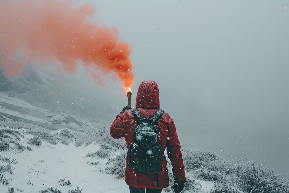 Hiker holding a distress signal flare mountain outdoors winter.