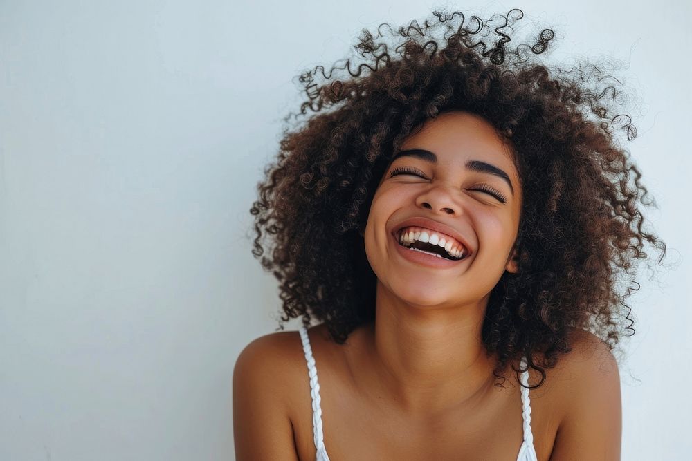 Afican american woman with white top laughing smile adult face.