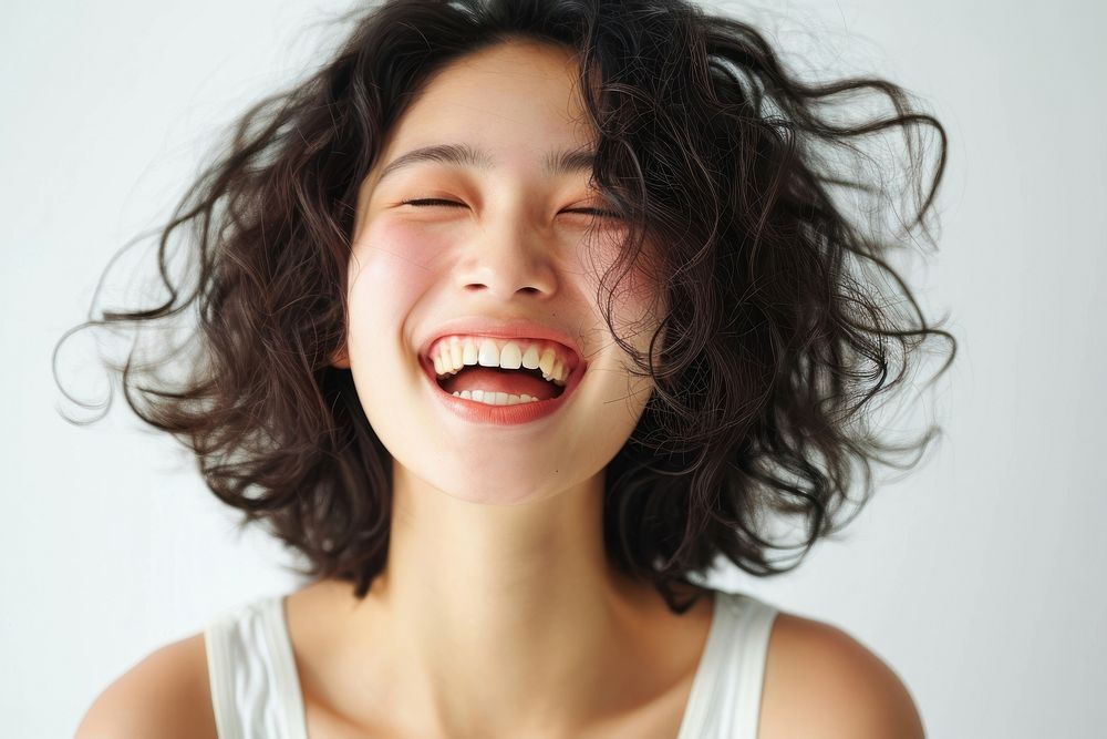 Asian woman with white top laughing smile face relaxation.