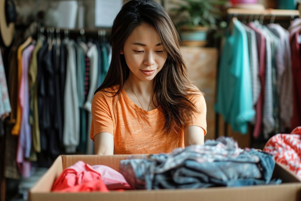 Asian american woman packing box small business.