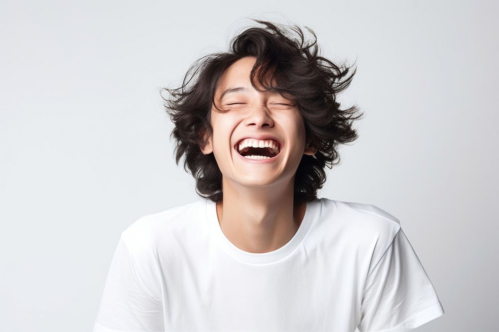 Asian man with white top laughing shouting adult face.