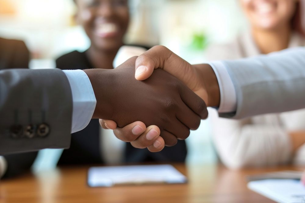 Businesspeople shaking hands handshake table cooperation.