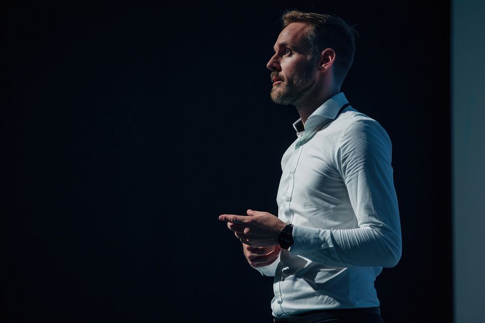 Man standing presenting project in conference hall adult shirt technology. AI generated Image by rawpixel.