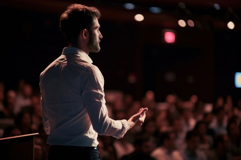 Man standing presenting project in conference hall audience adult performance. AI generated Image by rawpixel.