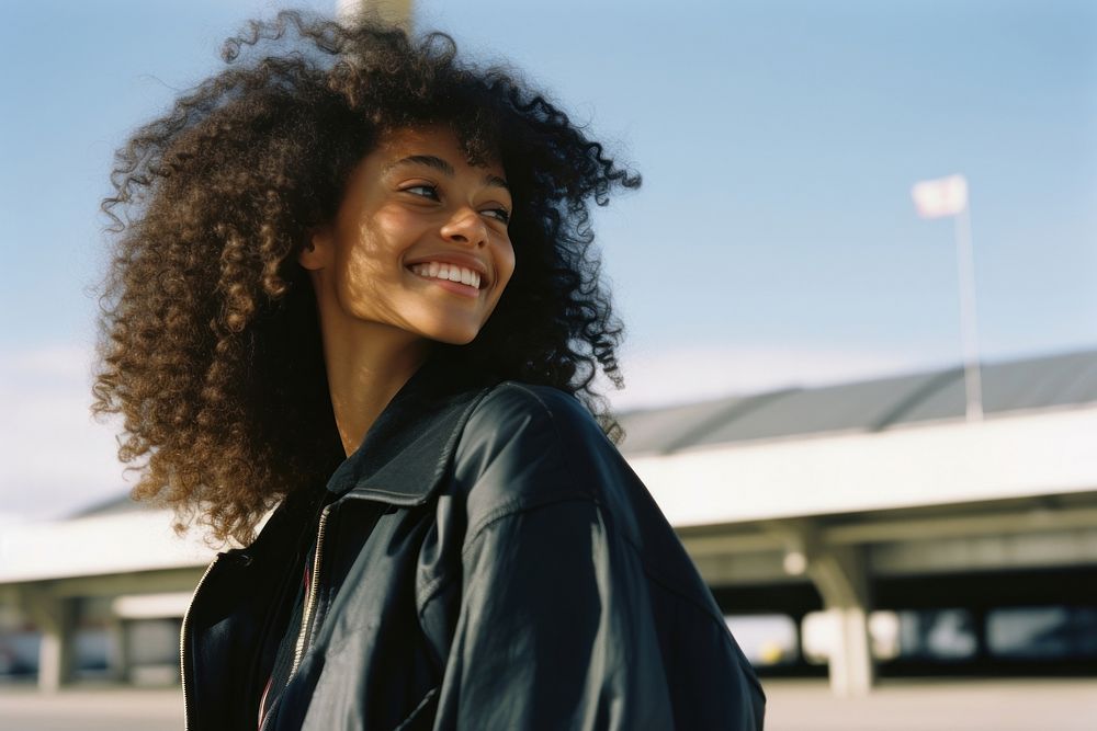African-American woman smiling at airport fashion jacket adult.