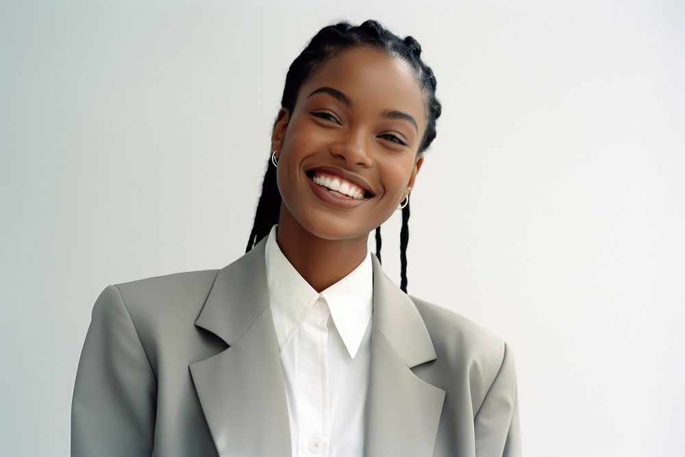 African-American woman in suit smiling and thinking smile dreadlocks hairstyle.