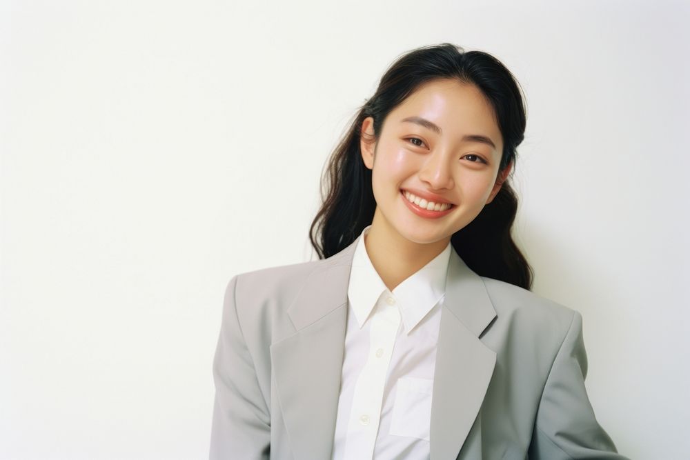 Asian woman in suit smiling and thinking adult smile white background.