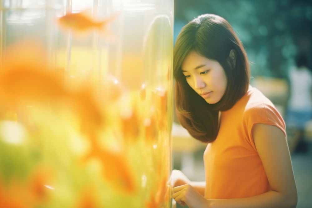 A asian woman looking in the gold fish tank contemplation photography relaxation. AI generated Image by rawpixel.
