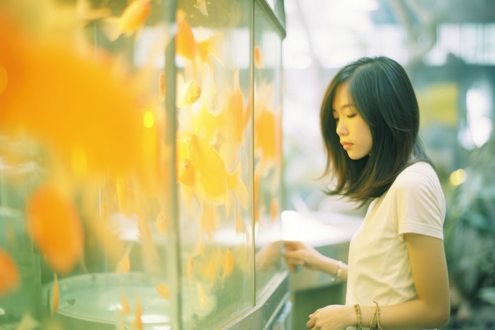 A asian woman looking in the gold fish tank contemplation hairstyle happiness. AI generated Image by rawpixel.