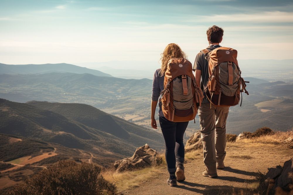 Two people hiking with backpack along a hillside backpacking recreation adventure.