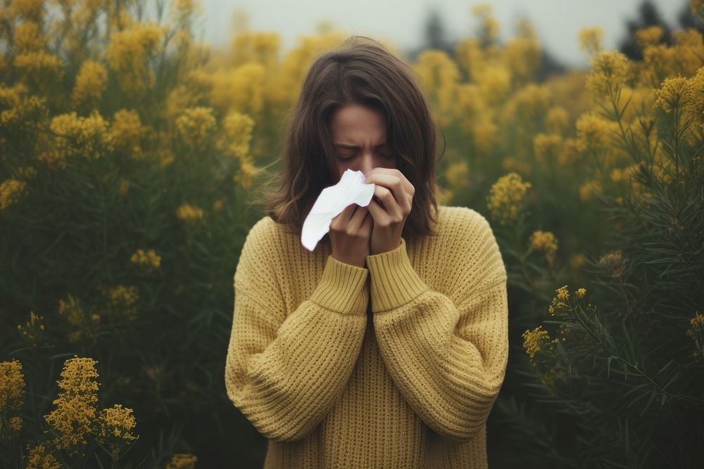 Young woman blowing her nose outdoors sweater hand. AI generated Image by rawpixel.