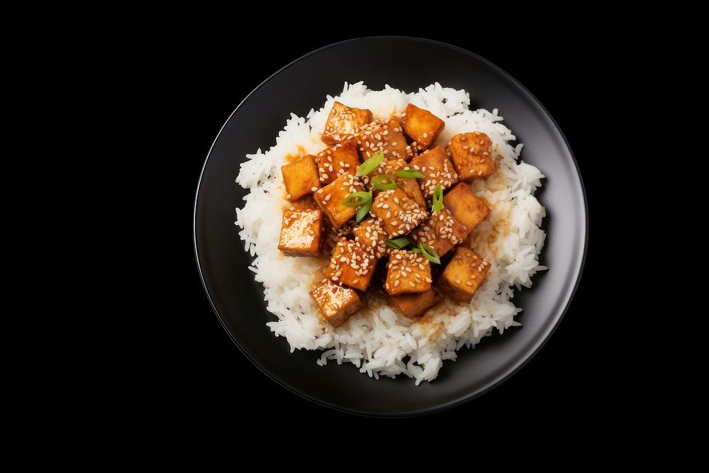A rice and fried tofu with sesame seeds on the black plate food meat vegetable.