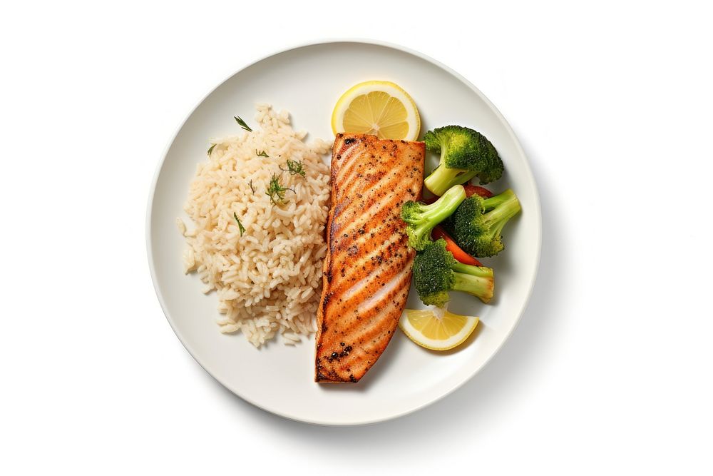 A salmon steak with rice and boiled vegetables as a side an a slice of lemon on the white plate food seafood white…
