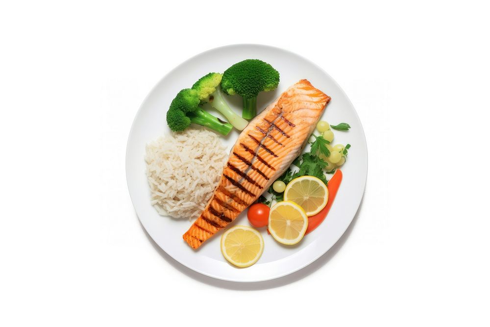 A salmon steak with rice and boiled vegetables as a side an a slice of lemon on the white plate food seafood lunch.