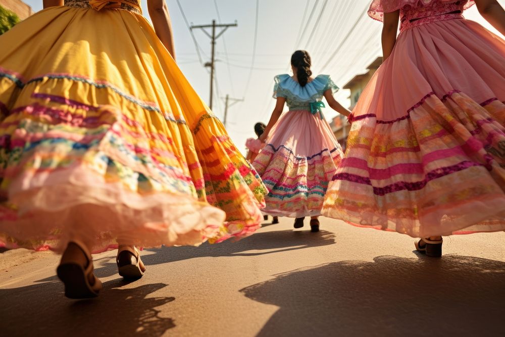 Mexican women dancers dressed with colorful skirts marching down a street in the country celebration dancing walking.
