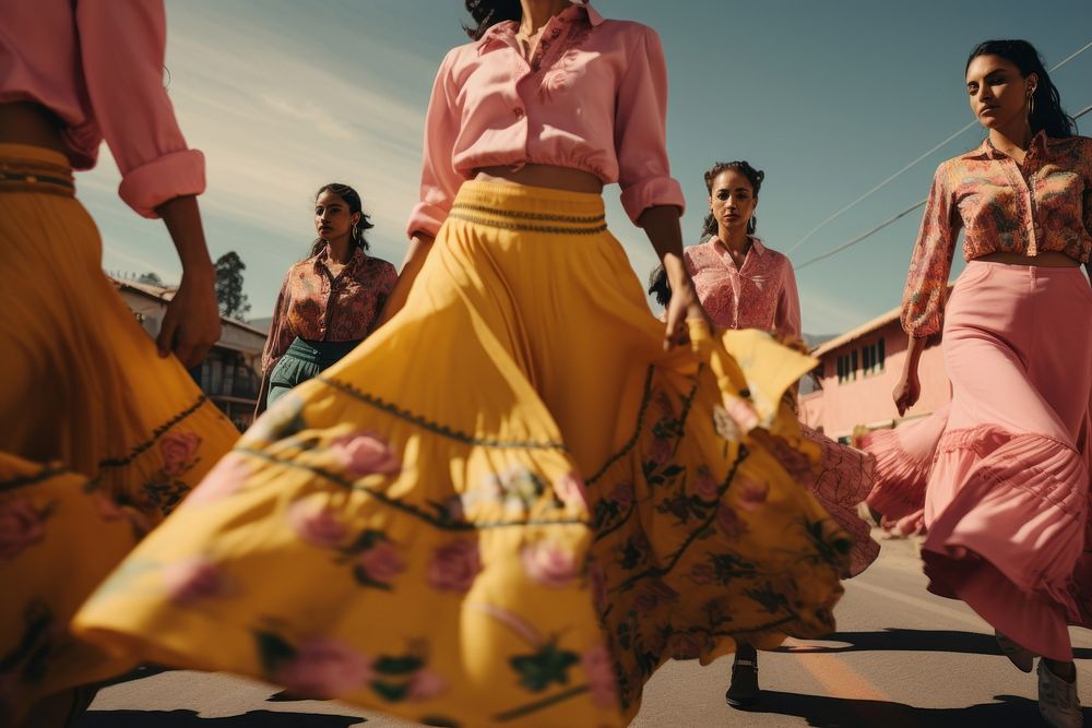 Mexican women dancers dressed with colorful skirts marching down a street in the country dancing yellow adult.