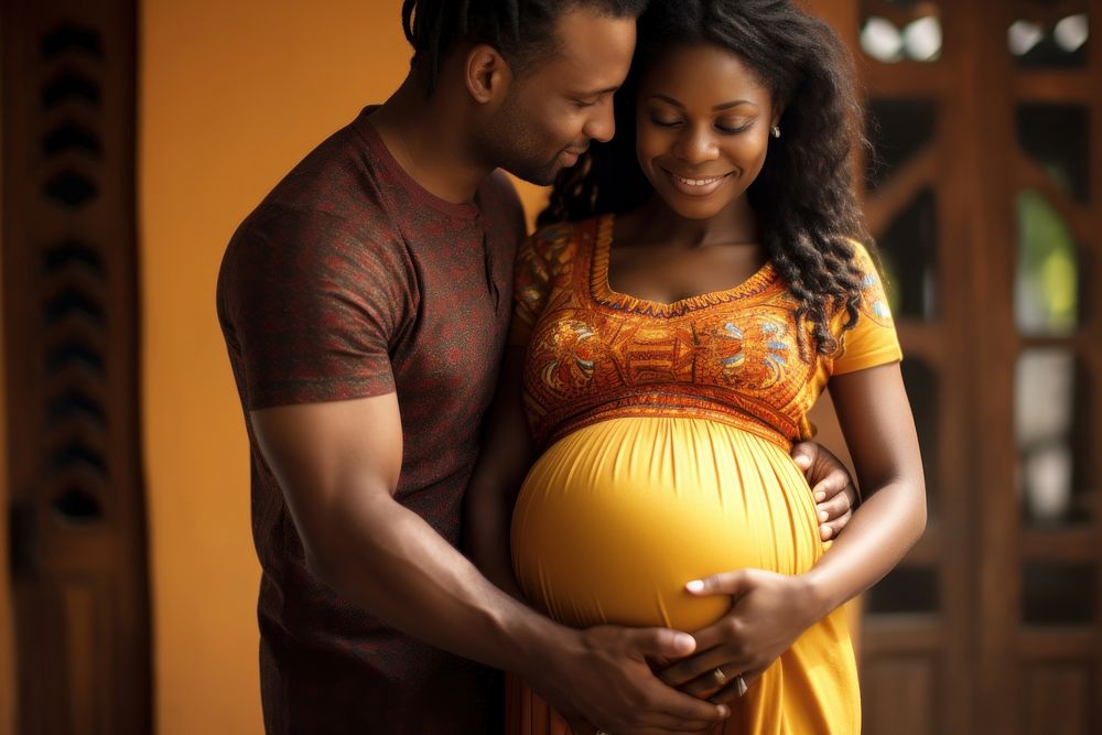 Mid adult couple expecting a baby while husband caresses the belly of his pregnant african woman touching love men.
