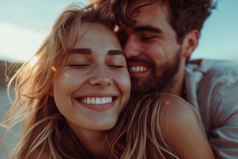 Woman kissing her smiling boyfriend on a cheek laughing portrait happy.