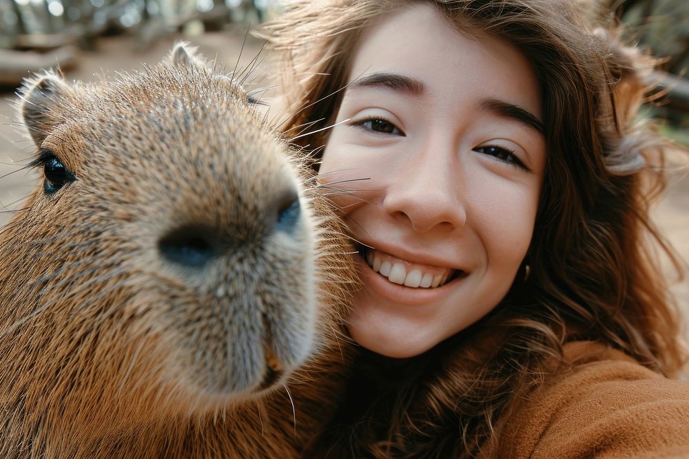 Capybara and young woman animal portrait smiling.