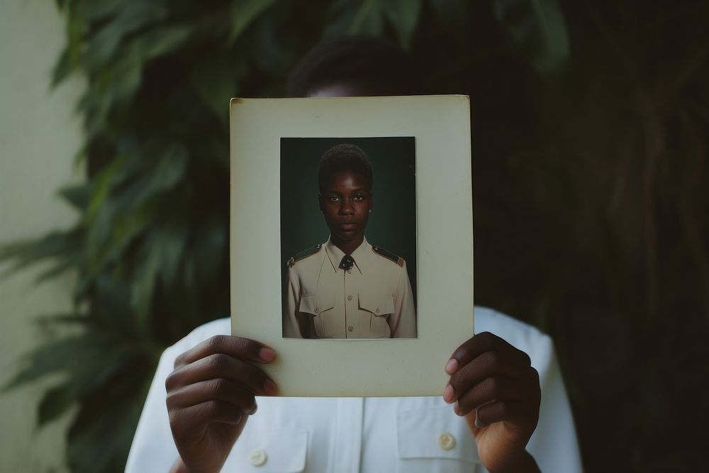 African student in white uniform holding hand portrait.