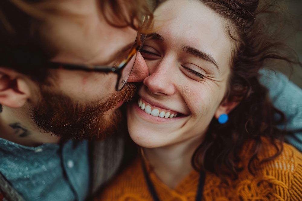 Woman with blue earring kissing laughing smiling adult.