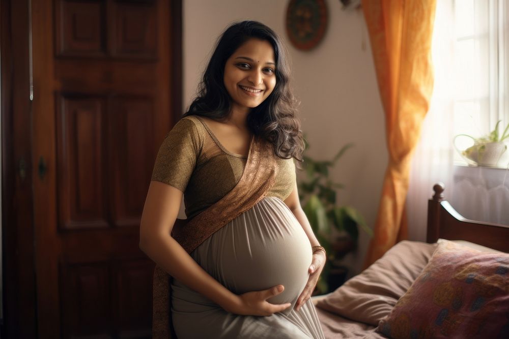 Happy pregnant woman in a living room portrait adult photo.