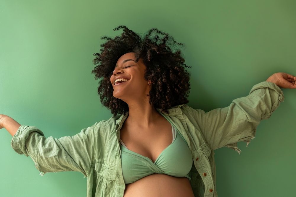 Pregnant black woman laughing smiling dancing.