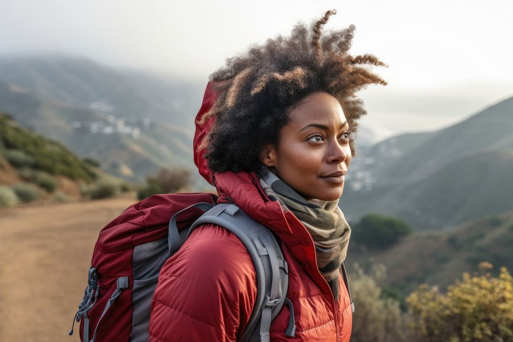 Middle-aged African American female backpacker photography mountain travel.