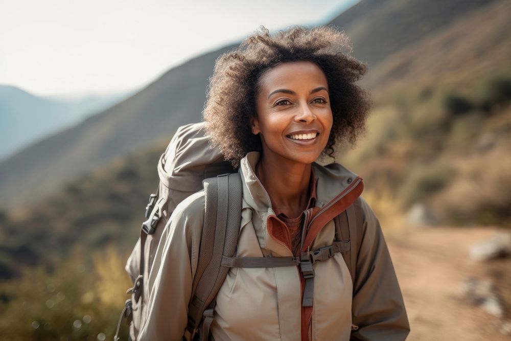 Middle-aged African American female backpacker mountain walking travel.