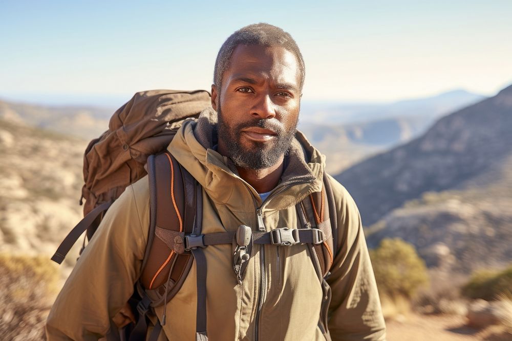 Middle-aged male African American backpacker mountain walking travel.