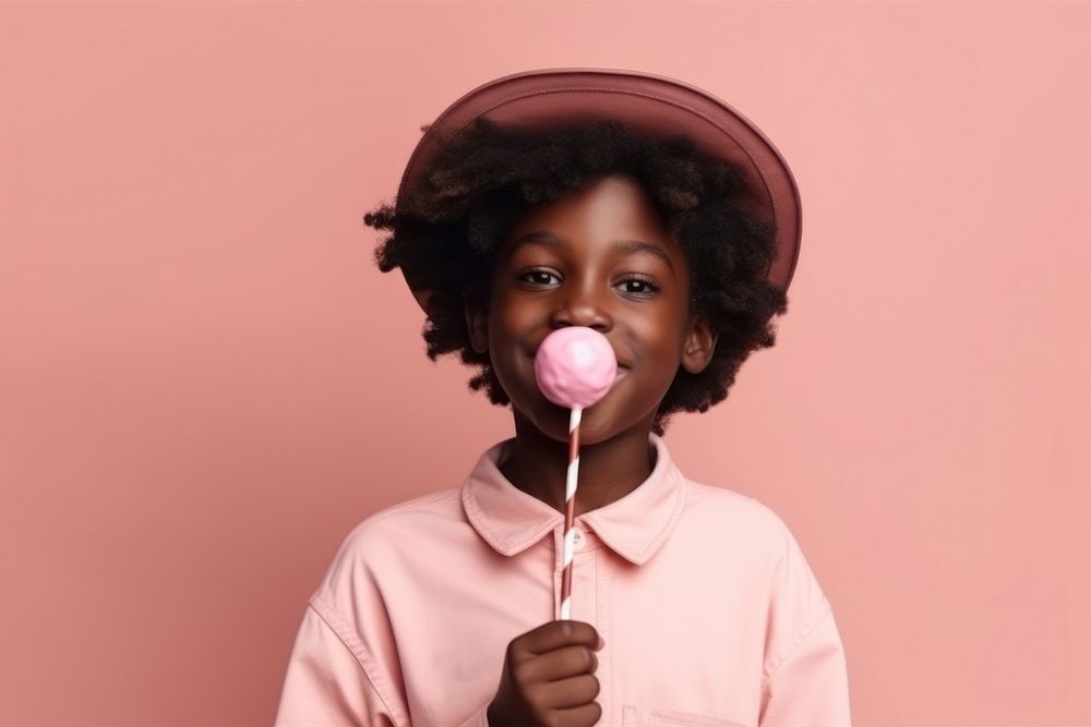 African American boy with lolly pink food confectionery.