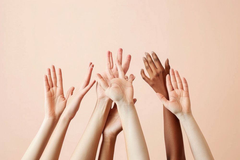 A group of hands reaching up and holding on to each other finger skin gesturing.