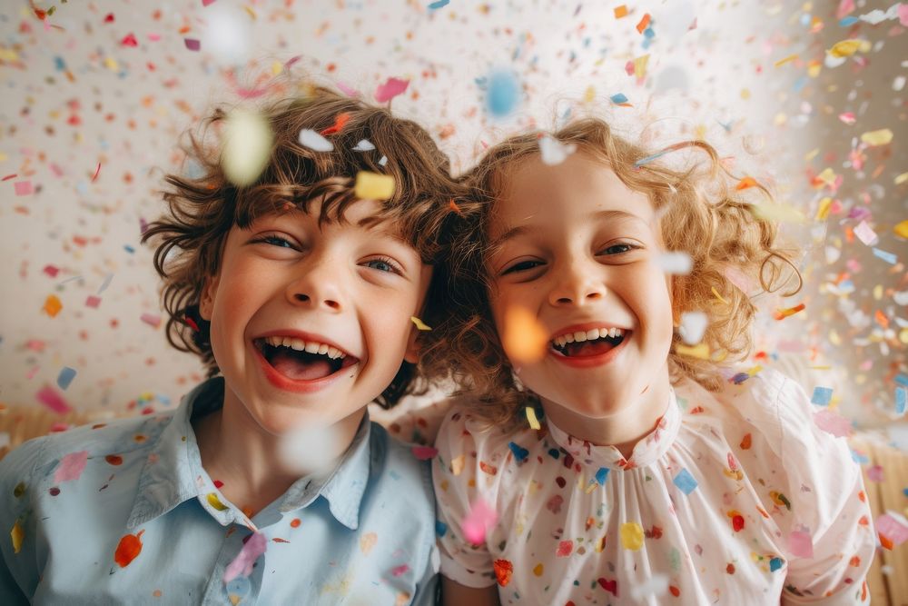 Cheerful boy and girl laughing confetti portrait.