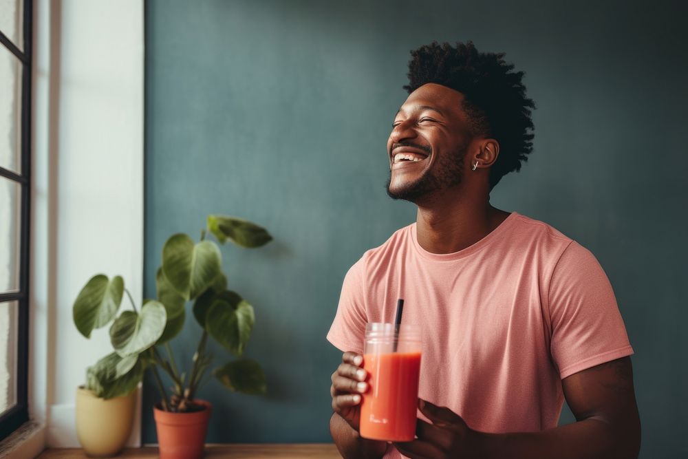 Black man drinking a vegetable smoothie laughing smile adult.