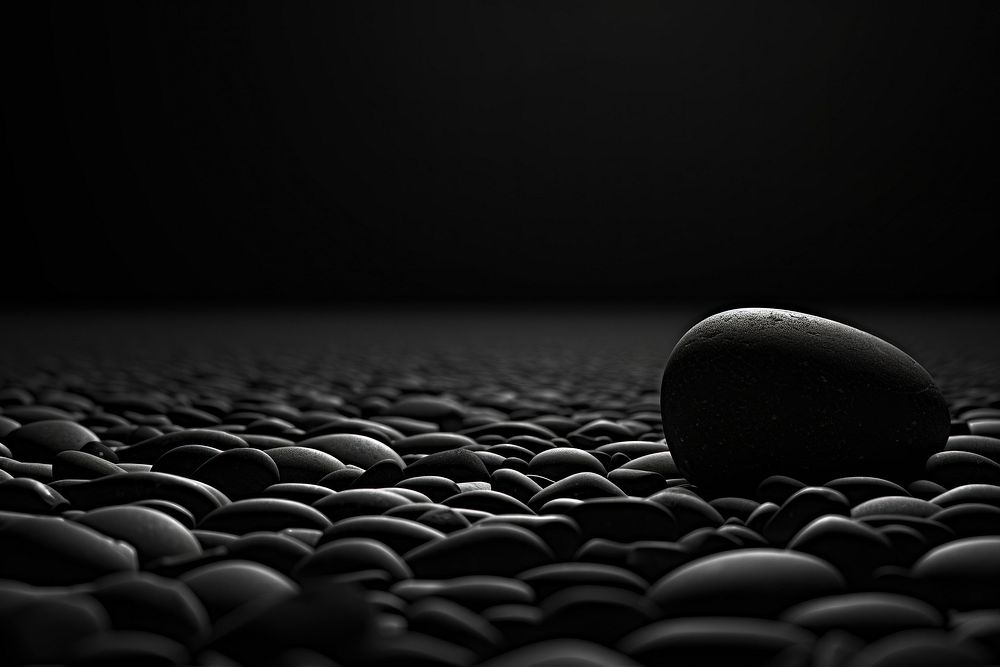 Dark background black monochrome pebble.