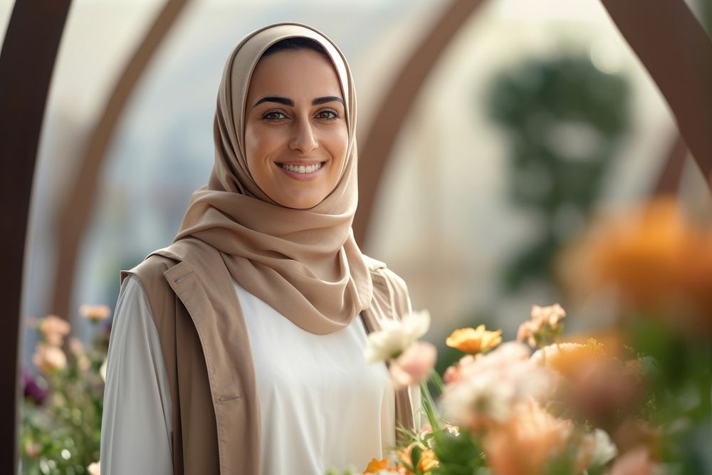 A happy Middle east woman gardener in flower garden looking scarf smile.