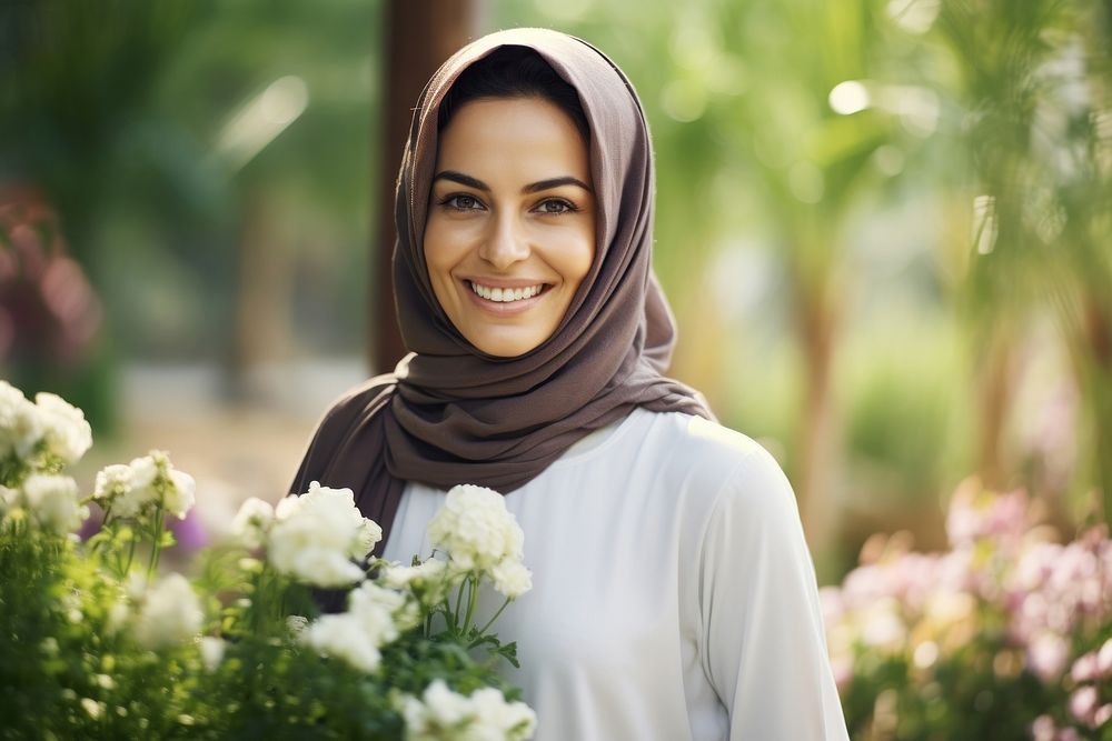 A happy Middle east woman gardener in flower garden looking smile scarf.